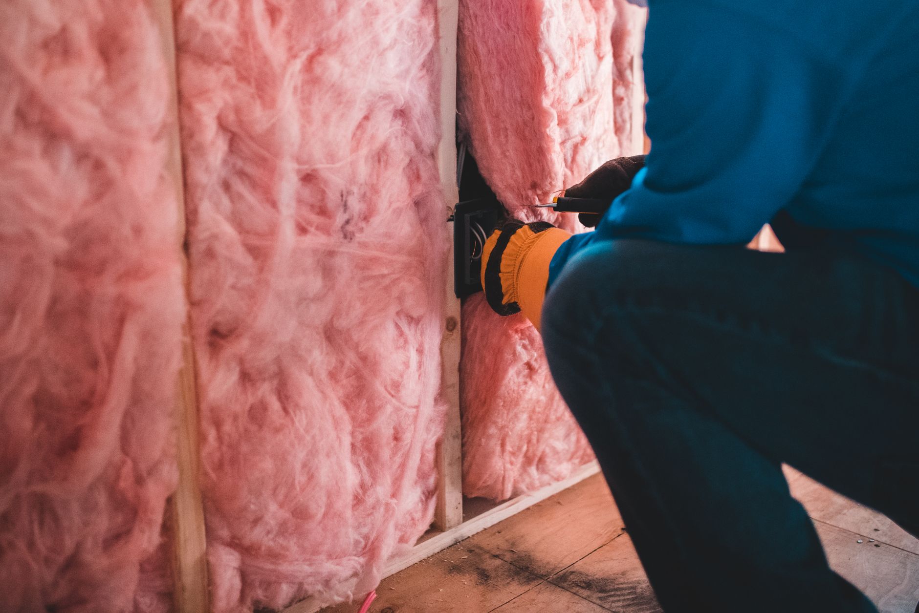 Un professionnel pose un isolant dans les combles d’une maison.